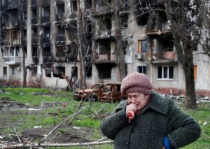 Tamara, 71, cries in front of an apartment building destroyed during Ukraine-Russia conflict in the southern port city of Mariupol 