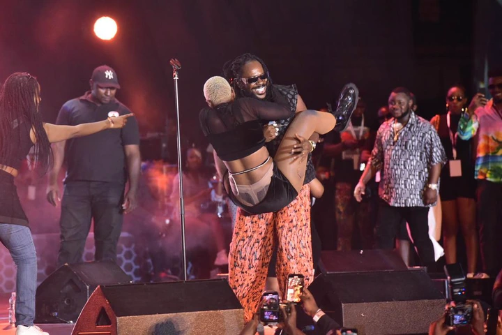 Simi Reacts As Ugandan Girl Rocks Adekunle Gold After Jumping On Him On Stage