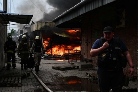 Firefighters work to control flames at the central market of Sloviansk on July 5