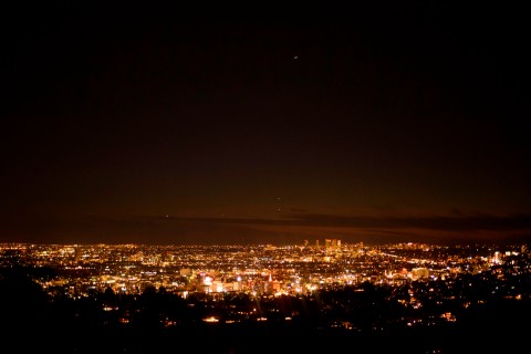 Planets Jupiter and Saturn (C, top) are seen above the Los Angeles skyline as seen from the Griffith Observatory in 2020.